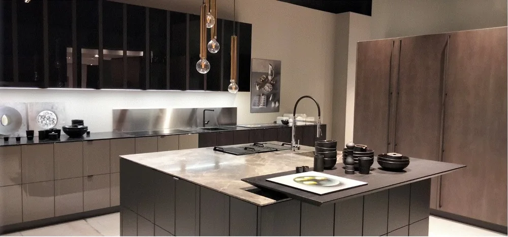 Render 3D di una cucina con isola scura, piano in pietra e lampade a sospensione